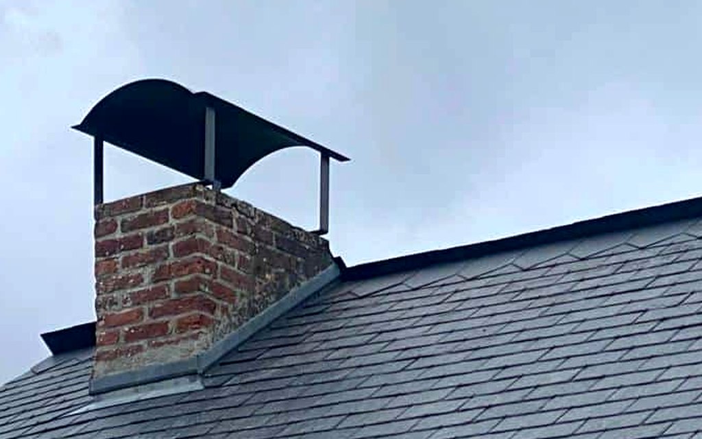 Abergement en zinc au pied d'une souche de cheminée sur toiture ardoise par CF Couverture